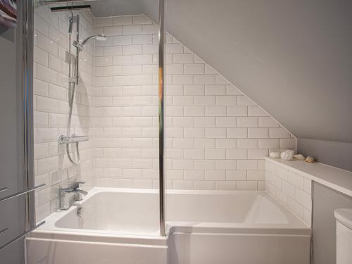 Carinish的住宿－Heatherlea，浴室设有带淋浴的白色浴缸。