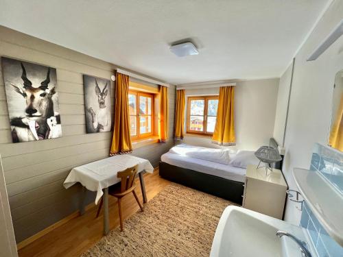 a bedroom with a bed and a bathroom with a sink at Lech Hostel in Lech am Arlberg