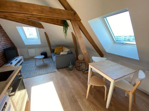a room with a table and chairs in a attic at Chez Mathilde Studio Calais Nord Citadelle in Calais