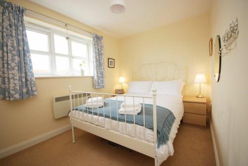 a bedroom with a white bed and a window at House Martins Beadnell in Beadnell