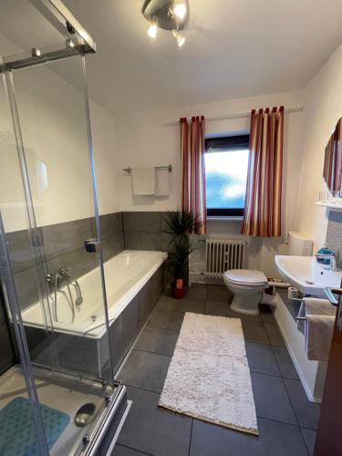ein Badezimmer mit einer Badewanne, einem WC und einem Waschbecken in der Unterkunft Pension Erna in Zwiesel