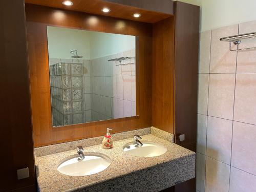 een badkamer met 2 wastafels en een grote spiegel bij Blue Bay BEACH Villa 25 3-min beach-pool-golf in Blauw Baai