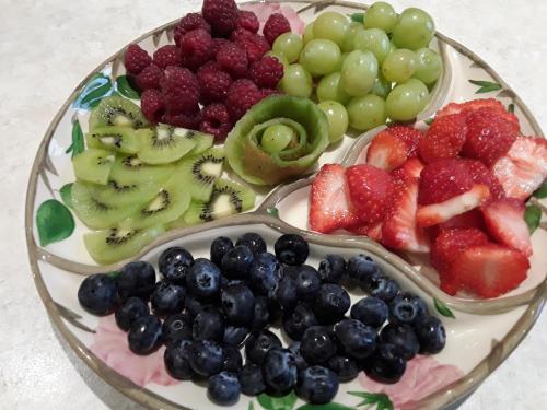a plate of fruit on a glass plate with cherries and strawberries at Ellerton Lodge Bed and Breakfast Swaledale in Richmond