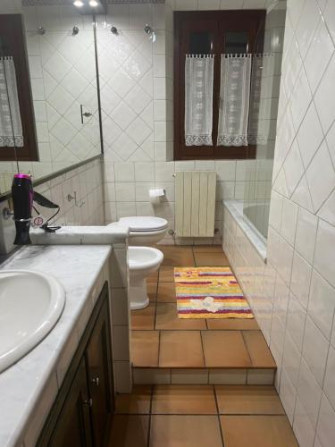 a bathroom with two sinks and a toilet and a tub at CASA LUCIO in Grosseto