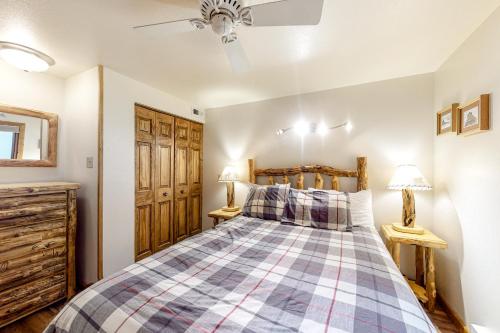1 dormitorio con 1 cama con manta a cuadros en Three Seasons Condominiums, en Crested Butte
