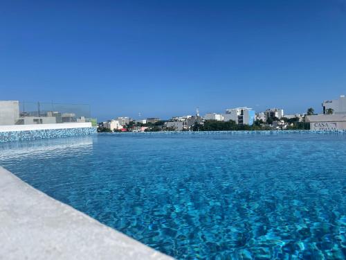 a pool of blue water with a city in the background at WIN DAY Playa - Hotel Express in Playa del Carmen