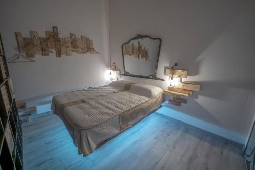 een slaapkamer met een bed met 2 lampen en een spiegel bij La casa della moda in Montescaglioso