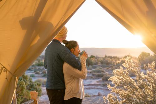 a man and a woman standing inside of a tent at ULUM Moab in La Sal