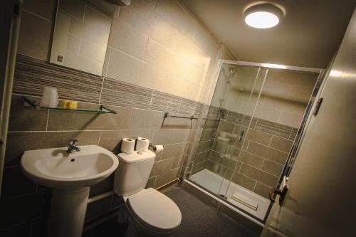 a bathroom with a toilet and a sink and a shower at Chatsworth House Hotel in Llandudno