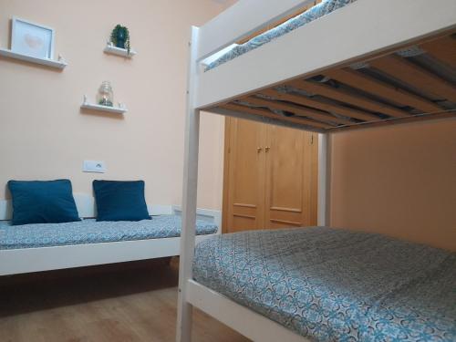 a bedroom with two bunk beds with blue pillows at El piso de La Zubia "La casa de los poemas" in La Zubia