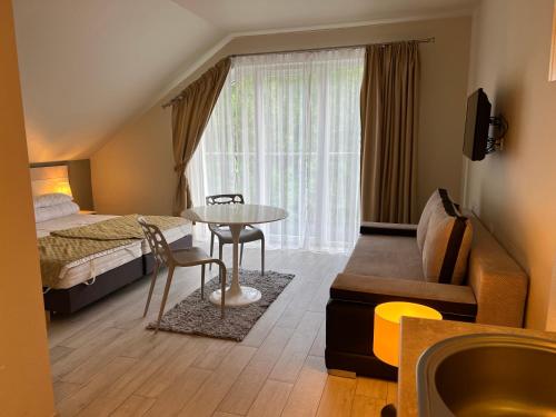 弦納的住宿－Apartament Czarna Góra - Resort - Solden - Sienna，酒店客房设有一张床铺、一张桌子和一个浴缸。