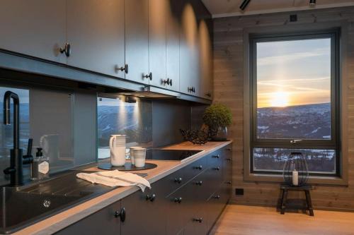cocina con fregadero y ventana grande en Splitter ny leilighet med panoramautsikt, en Beitostølen