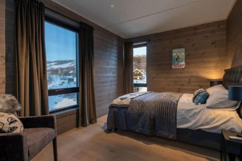 1 dormitorio con cama y ventana grande en Splitter ny leilighet med panoramautsikt, en Beitostølen
