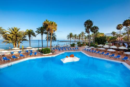 
a beach scene with a large swimming pool at Sol Tenerife in Playa de las Americas
