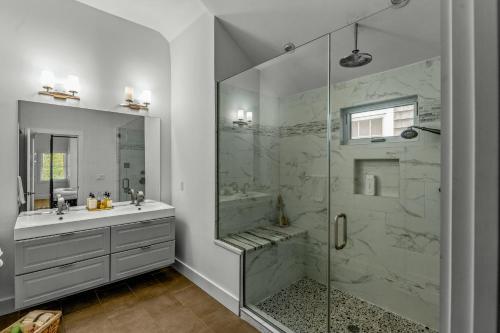uma casa de banho branca com um chuveiro e um lavatório. em Modern on 9th em Greenport