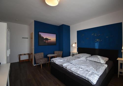 a blue bedroom with a bed and a blue wall at Hotel Sonnenschein - Spielerei im Sonnenschein in Dahme