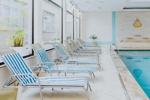 a row of chairs sitting next to a swimming pool at Hotel Minas Gerais in Poços de Caldas