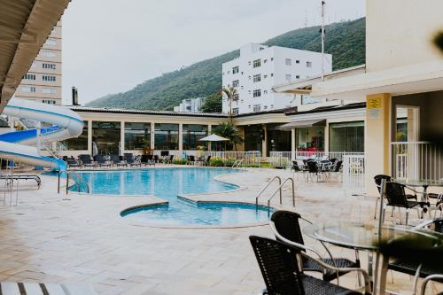 a swimming pool with a slide in a building at Hotel Minas Gerais in Poços de Caldas