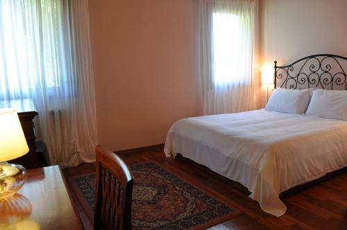 a bedroom with a white bed and a window at Locanda degli Ulivi in Arcugnano