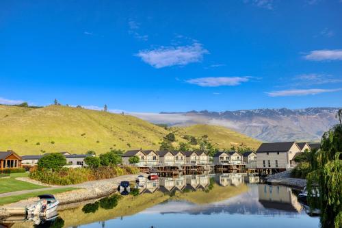 a view of a river with houses and a mountain at Marsden Lake Resort Central Otago in Cromwell
