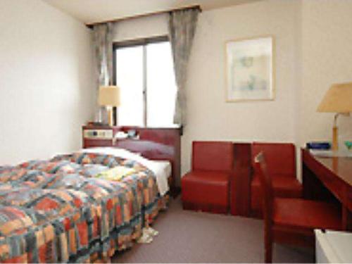 a bedroom with a bed and a chair and a window at Hotel Bayside Mihara - Vacation STAY 00520v in Mihara