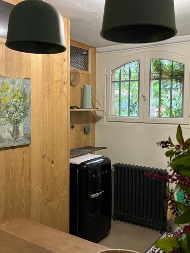 - une cuisine avec deux lumières noires au-dessus d'un réfrigérateur dans l'établissement Le clos sainte marie, à Roquefort-les-Pins