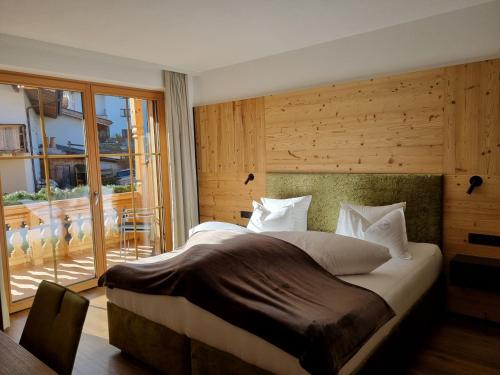 sypialnia z dużym łóżkiem i balkonem w obiekcie Greidlhof Alpstyle Apartments w mieście Fügen