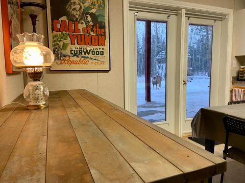 a wooden table with a lamp on top of it at The Big Red Barn in Whitehorse
