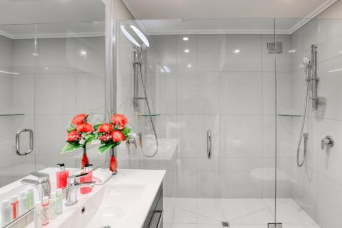 a white bathroom with a sink and a shower at Marsden Lake Resort Central Otago in Cromwell