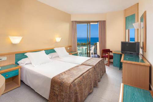 a hotel room with a large bed and a television at Sol Tenerife in Playa de las Americas
