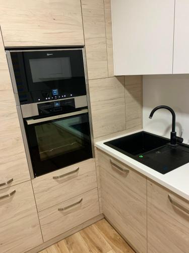 a kitchen with a microwave oven and a sink at Alytus Apartament in Alytus