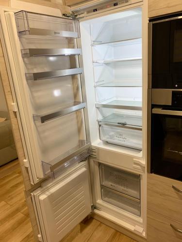 an empty refrigerator with its door open in a kitchen at Alytus Apartament in Alytus