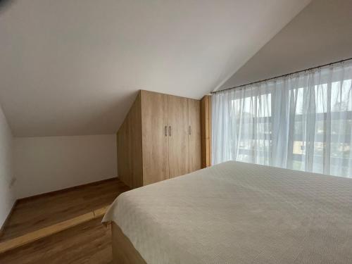a bedroom with a bed and a large window at U plechového Jánošíka in Terchová