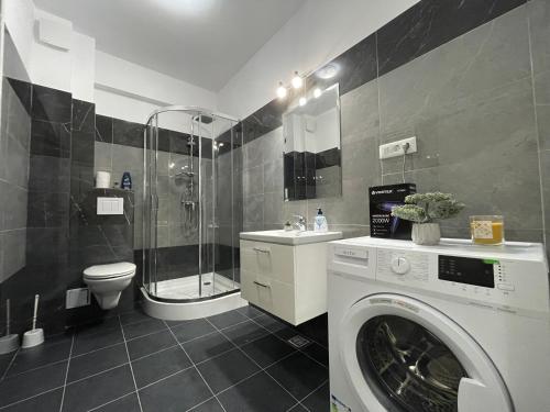 ein Bad mit einer Waschmaschine und einer Dusche in der Unterkunft Luxury Charming Apartments in Iaşi