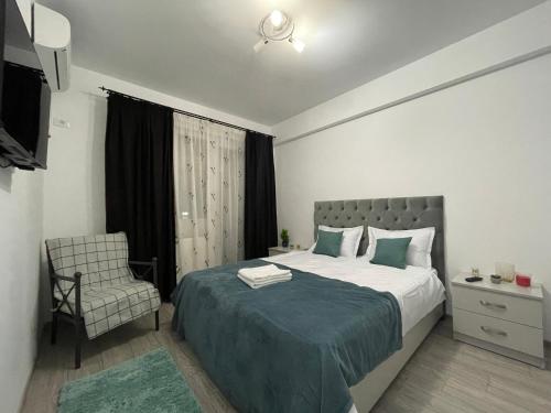 una camera con un grande letto e una sedia di Luxury Charming Apartments a Iaşi