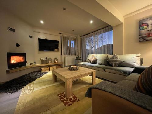 Mountain Home / Center Arachova في أراخوفا: غرفة معيشة مع أريكة ومدفأة