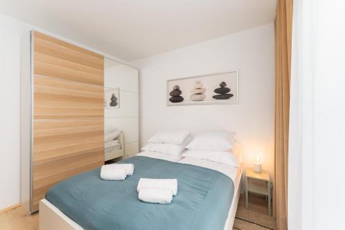 een slaapkamer met een bed met twee handdoeken erop bij Apartament SUBMARINE SurfingBird Dźwirzyno in Dźwirzyno