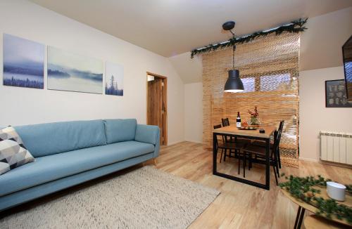a living room with a blue couch and a table at KOKICHE 4 Friends, Borovets in Borovets