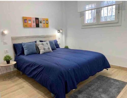 sypialnia z dużym niebieskim łóżkiem w pokoju w obiekcie Apartamento 4 personas w Madrycie