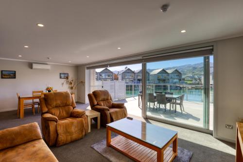 a living room with a couch and chairs and a table at Marsden Lake Resort Central Otago in Cromwell