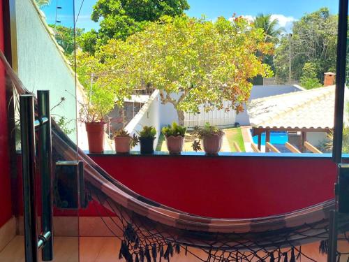 a red boat on a balcony with potted plants at Casa espaçosa 15h 800m praia in Porto Seguro