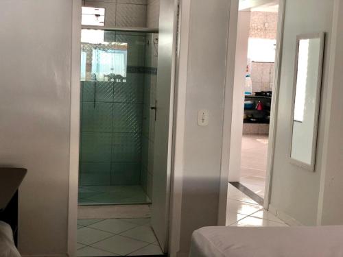 a bathroom with a shower with a glass door at Casa espaçosa 15h 800m praia in Porto Seguro