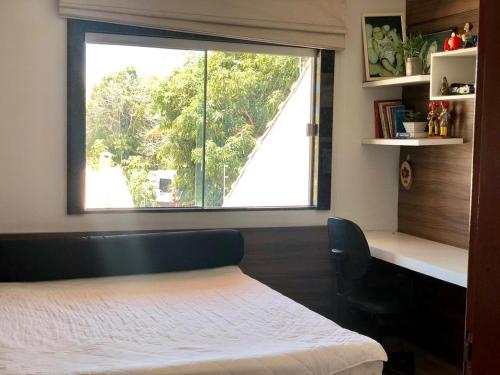 1 dormitorio con cama y ventana grande en Casa espaçosa 15h 800m praia, en Porto Seguro