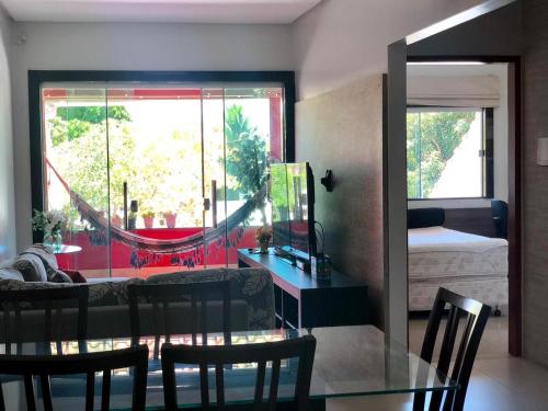 a living room with a glass table and a hammock at Casa espaçosa 15h 800m praia in Porto Seguro