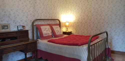 a bedroom with a bed with red pillows and a desk at MAISON DE CHARME AVEC JARDIN CLOS in Rivedoux-Plage