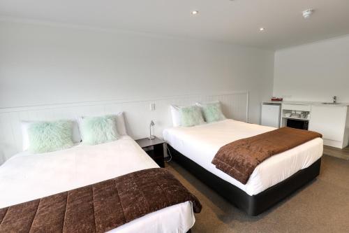 two beds sitting next to each other in a room at Marsden Lake Resort Central Otago in Cromwell