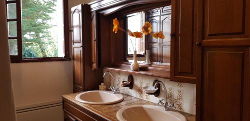 un bagno con due lavandini e una finestra di MAISON DE CHARME AVEC JARDIN CLOS a Rivedoux-Plage