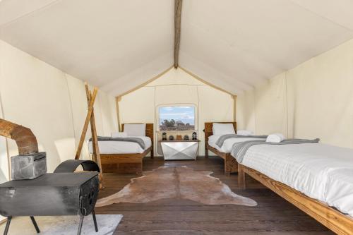 a room with four beds in a tent at Under Canvas Moab in Moab