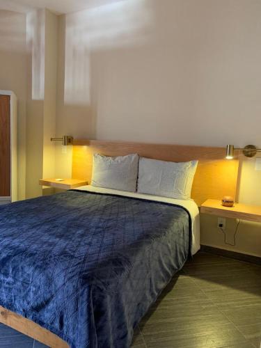 ein Schlafzimmer mit einem großen Bett mit einer blauen Decke in der Unterkunft Sierra Norte By Chic Hotel Group in Tepoztlán