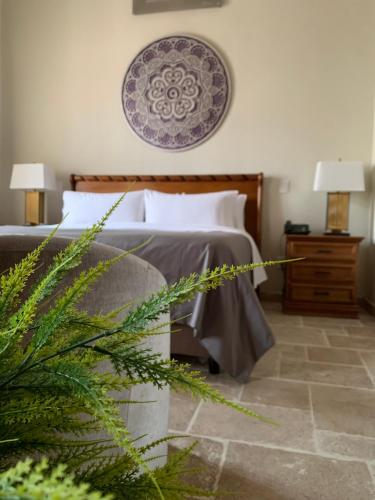 a bedroom with a bed and a plant in the foreground at Dos Patios Querétaro Curamoria Collection in Querétaro